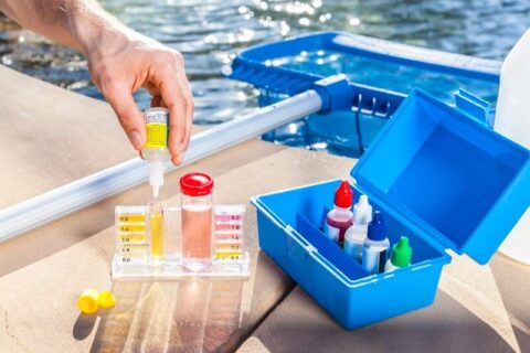 A person is testing pool water with a test kit to find a pool problem in Phoenix, AZ