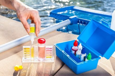 A person is testing pool water with a test kit to find a pool problem in Phoenix, AZ