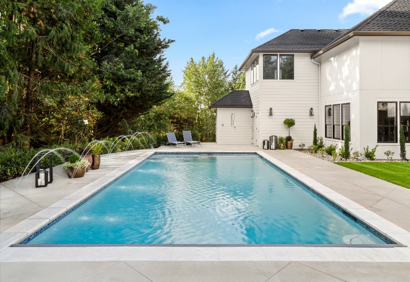 Newly constructed residential pool beside a modern white home in Phoenix, AZ